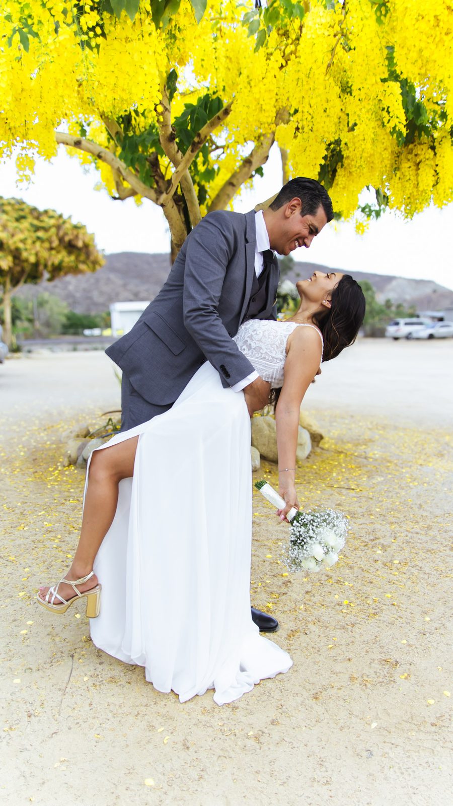 Newlyweds beneath a yellow flowering tree, photographed by Julie St-Louis